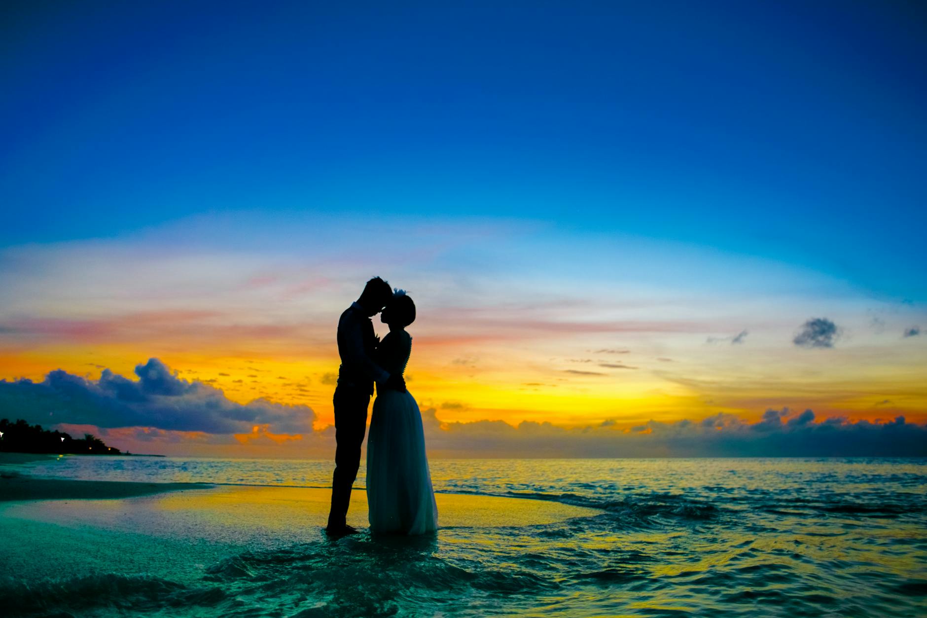 Retired couple sitting together looking out over the water at sunset
