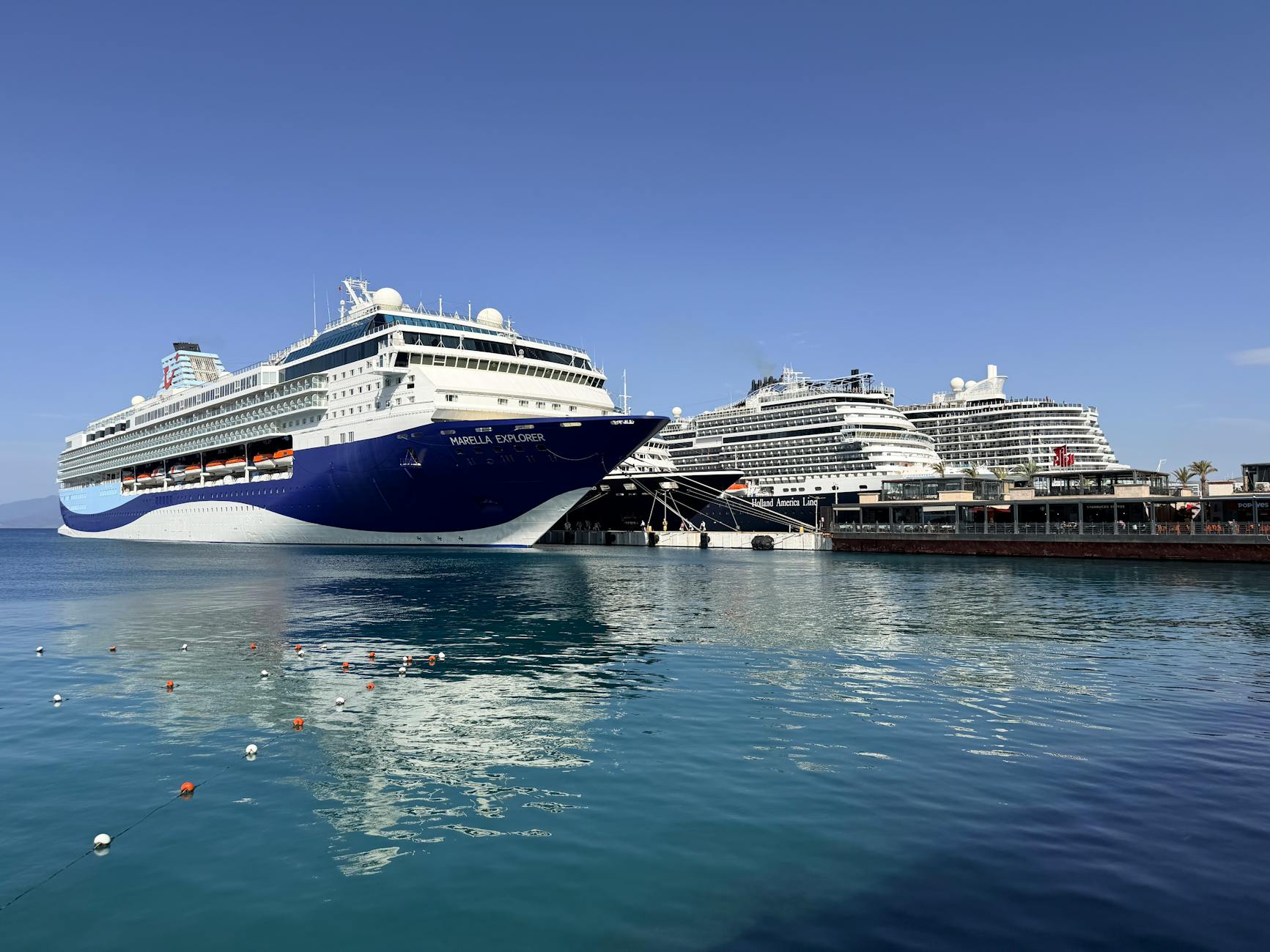 Cruise ships docked in calm water on a clear morning